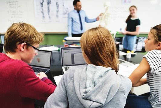 Students working on laptops in a classroom